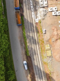 Aerial view of railway tracks and construction work, with a passing car, construction of the