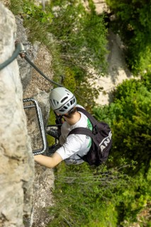 Mountaineer climbing over a steep ladder in the Isidor via ferrata, Grünstein, Schönau am