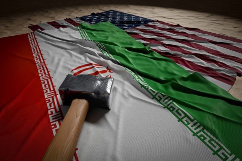 Large hammer, american and Iranian flags resting on desert sand