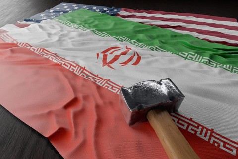 Large hammer resting on american and Iranian flags