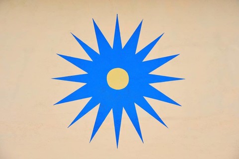 Blue stylised star with yellow centre on beige background, Rüdesheim am Rhein, Rhine Valley,