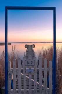 View along a footbridge through a door frame to the Steinhuder Meer in the evening light, Great