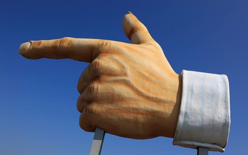 Plastic sculpture of a human hand with an outstretched index finger to indicate a direction