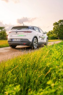 Rear view of a Renault on a country road surrounded by meadows, Deer E- CarSharing, Renault Megane
