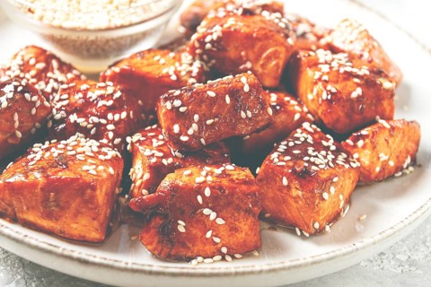 Fried pieces of salmon teriyaki with sesame seeds, top view