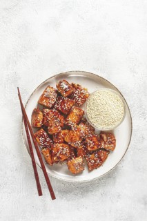 Fried pieces of salmon teriyaki with sesame seeds, top view