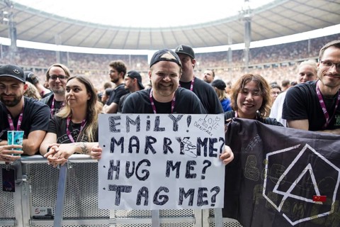 A fan holds a poster with the words Emily! Marry me? Hug me? Tag me? (Emily! Marry me? Hug me? Link