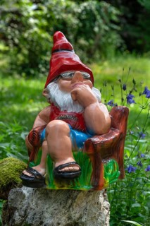 Sitting garden gnome in a garden, Bavaria, Germany