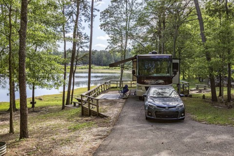 Motorhome parked in a campsite on the bank of the lake at Little Black Creek campground near