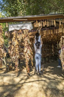 Thai women hanging their personal message plaque near the entrance to the Akha Cottage restaurant