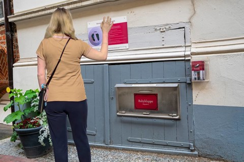 Woman waving in front of baby hatch