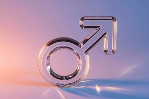 Male gender symbol made out of glass on pink background symbolizing fragile masculinity.