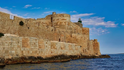Castello Maniace, Maniace sea fortress, old castle by the sea under a blue sky, surrounded by stone