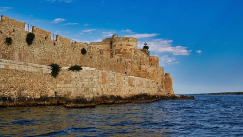 Castello Maniace, sea fortress Maniace, historic fortress on the water, striking under a clear blue