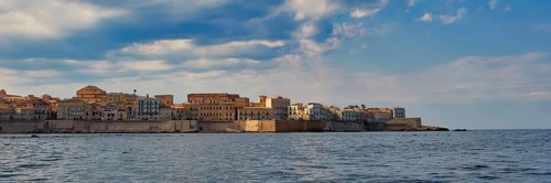 Historic city scenery on the coast under a slightly cloudy sky, boat trip around the island of