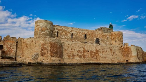 Castello Maniace, Maniace sea fortress, medieval castle with lighthouse by the sea under a blue
