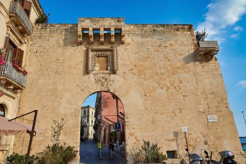 Historic stone city gate with visible road through the arch, Ortigia Island, Isola di Ortigia,