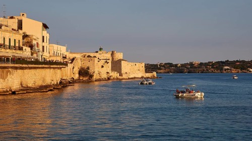 Castello Maniace, sea fortress Maniace, coastal town in the evening light with boats and historic