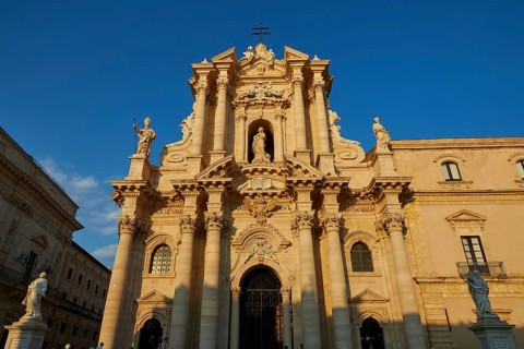 Cathedral of Syracuse, Magnificent facade of a cathedral in warm sunlight with detailed columns,