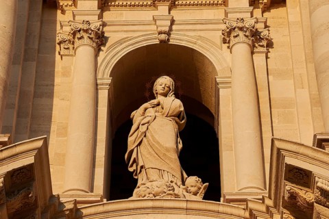 Cathedral of Syracuse, detail of a sculpture on the façade of a historic building with columns,
