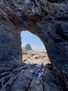 Large rock with a hole and people in the foreground, Hole in The Wall, Rialto Beach, Olympic