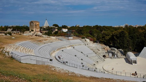 Greek amphitheatre, Ancient amphitheatre surrounded by green trees and historical ruins under a