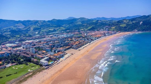 Aerial view of zarautz, gipuzkoa, showcasing the urban area meeting a golden sandy beach, with
