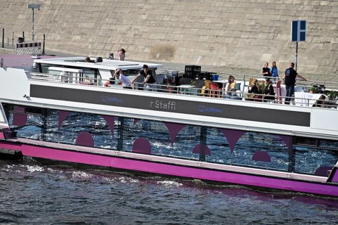 The media ship The Pionieer One sails on the Spree near the Kapelleufer