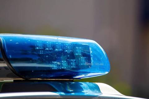 Symbolic image of a police operation: close-up of a flashing blue light on a police car