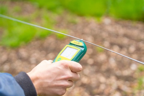 Hands holding a device for an electrical measurement on a wire, Waldweide Gechingen, compensation