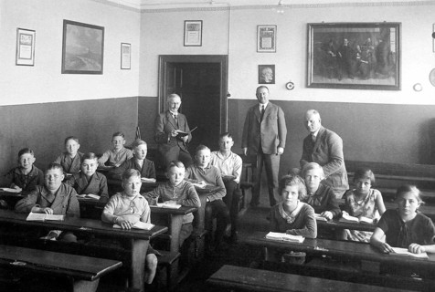 School class 3 teachers, ca. 1920, pupils sitting in a classroom, teacher standing, classical