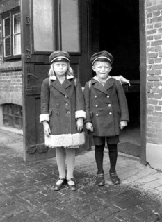 Brother sister pupil, 1920s, Two children in old-fashioned clothes stand seriously in front of an