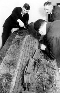 Men playing with a railway 1940, Men working concentrated on a model railway layout, historical