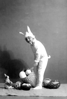 Girl dressed up as an Easter bunny, 1930s, A child in a bunny costume places a basket of eggs on