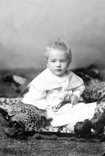 Little boy sitting on a leopard skin, 1910s, A little boy in a traditional outfit sits on a toy
