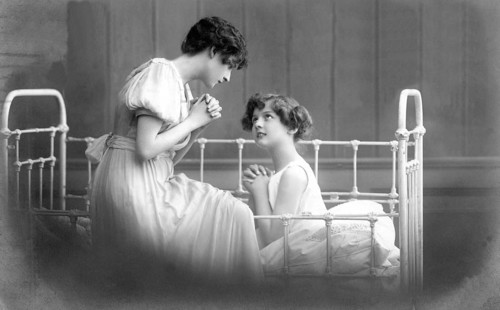 Two woman praying, 1930s, Two woman talking intimately on a bed, Historical photo