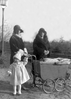 Two woman with pram and child, 1920s, Two woman and a child standing next to a pram, all in winter