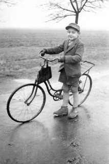 Boy with bicycle, 1920s, Boy standing with bicycle on a wet road in a rural environment, Historical
