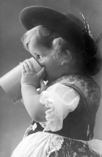 Girl drinking from a beer mug, 1930s, Small child in traditional traditional costume drinking from