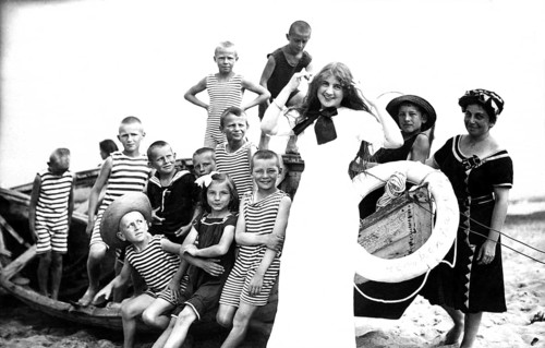Children's leisure time, 1920s, children in striped clothes and a woman posing smiling on the beach