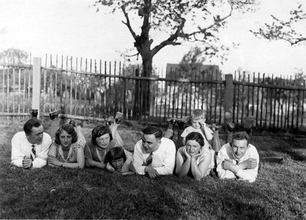 Large family lying in a row in the grass, 1930s, A group of people lying relaxed in the meadow on a