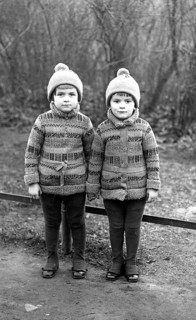 2 boys, twins, 1920, Two identical children in winter clothes standing next to each other outdoors,