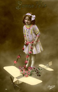 Girl with aeroplane, 1910, Girl in a purple dress posing with a toy aeroplane and flowers,