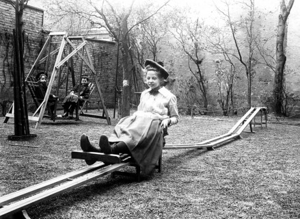 Girl on playground, 1910, Girl on a swing in an old courtyard with trees and a swing, historical