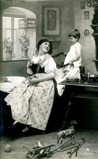 Child playing with mum's hair, 1920, A woman and a boy are inside, surrounded by toys, in a