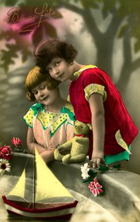 Two girls at play, 1930s, Two children in colourful clothes standing in front of a sailing boat