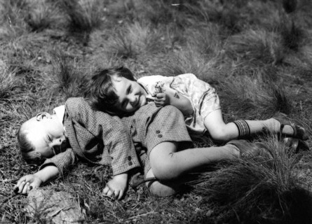 Boy and girl lying in a meadow, 1920, Two children lying relaxed in the meadow and enjoying the