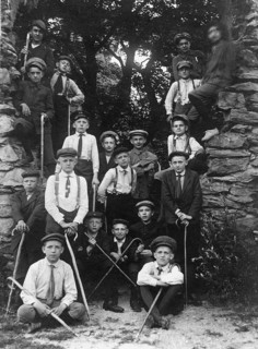 Group photo, 1920s, Group of boys in historical surroundings with walking sticks, Black and white