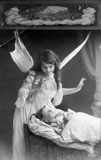 Angel at a child's bedside, 1920s, An angel watches over a sleeping child in a bed, Historical