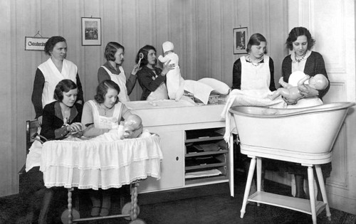 Midwifery school, 1930s, woman in uniforms, caring for dolls in a classical room, training
